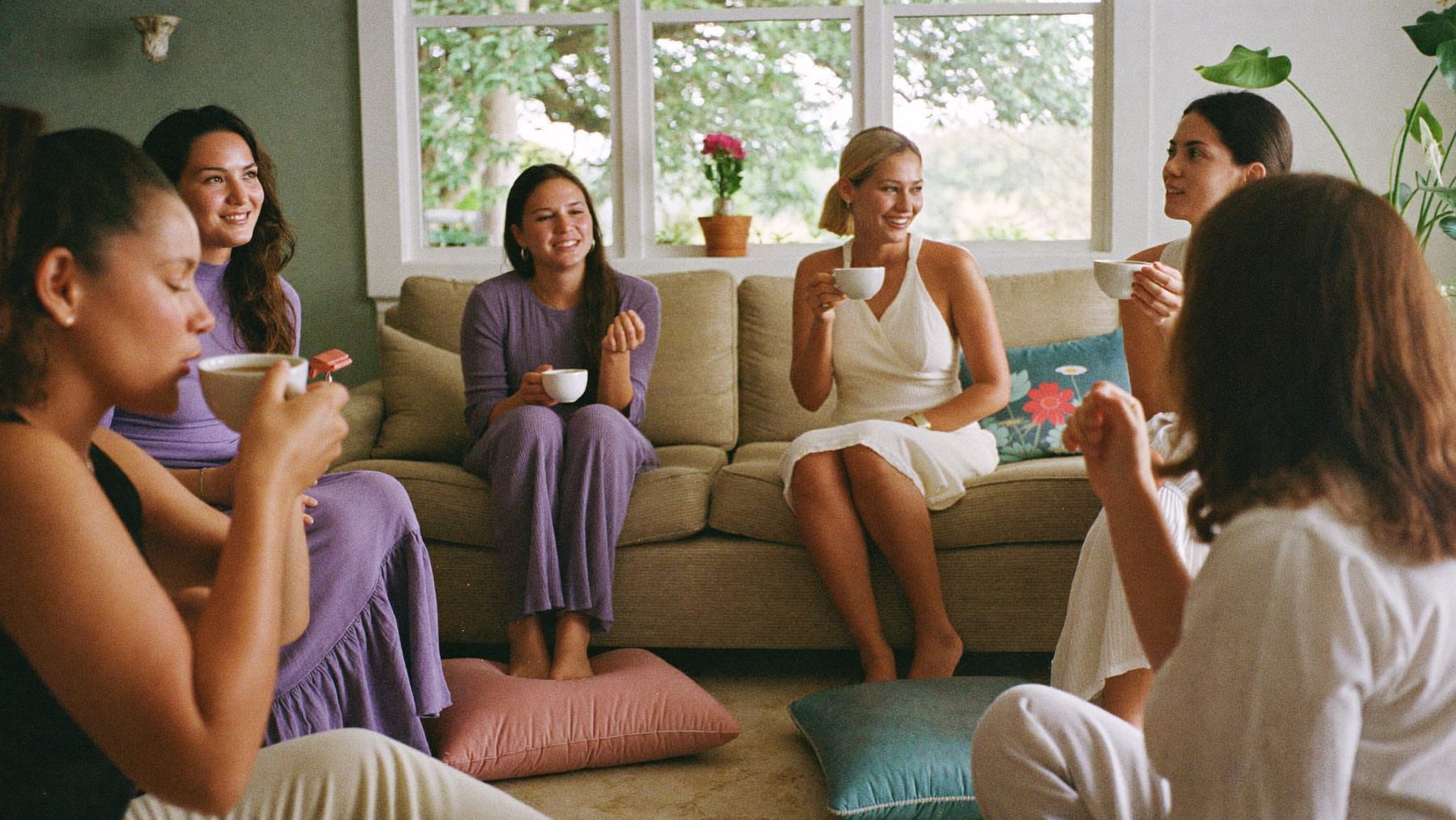 A small group of women talking and listening in a bright living room